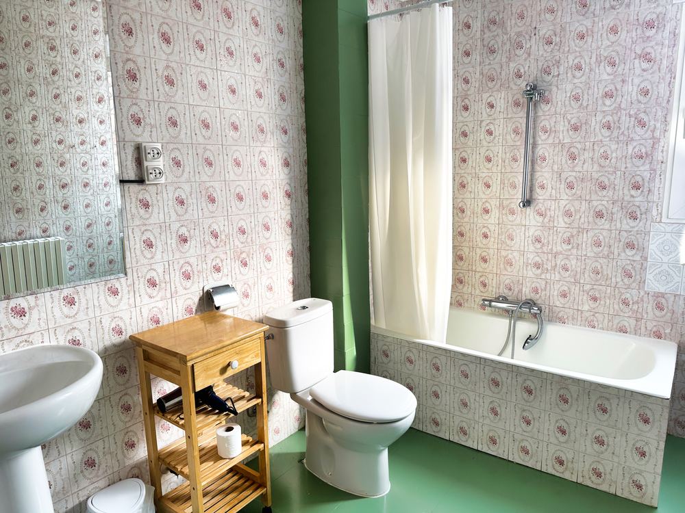 Baño planta primera con bañera y azulejo floral