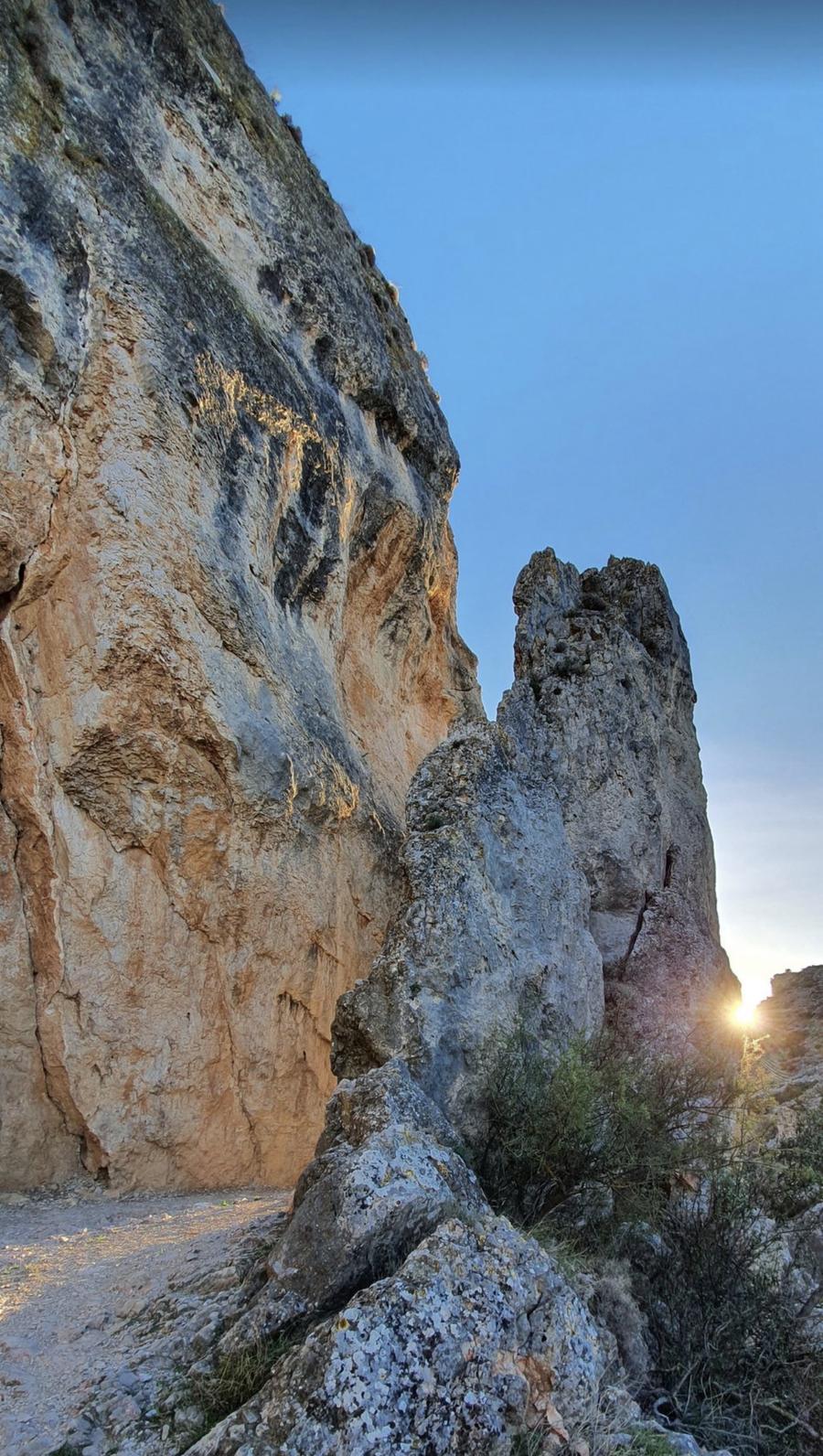 Paso de la Peña Tajada al atardecer, con el sol filtrándose entre las dos paredes de roca